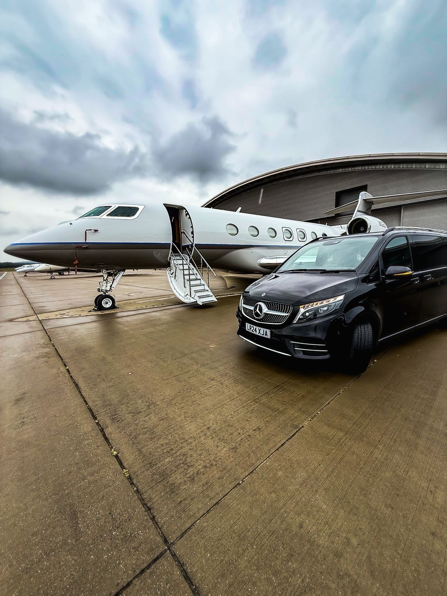 Chauffeur car waiting beside a private jet